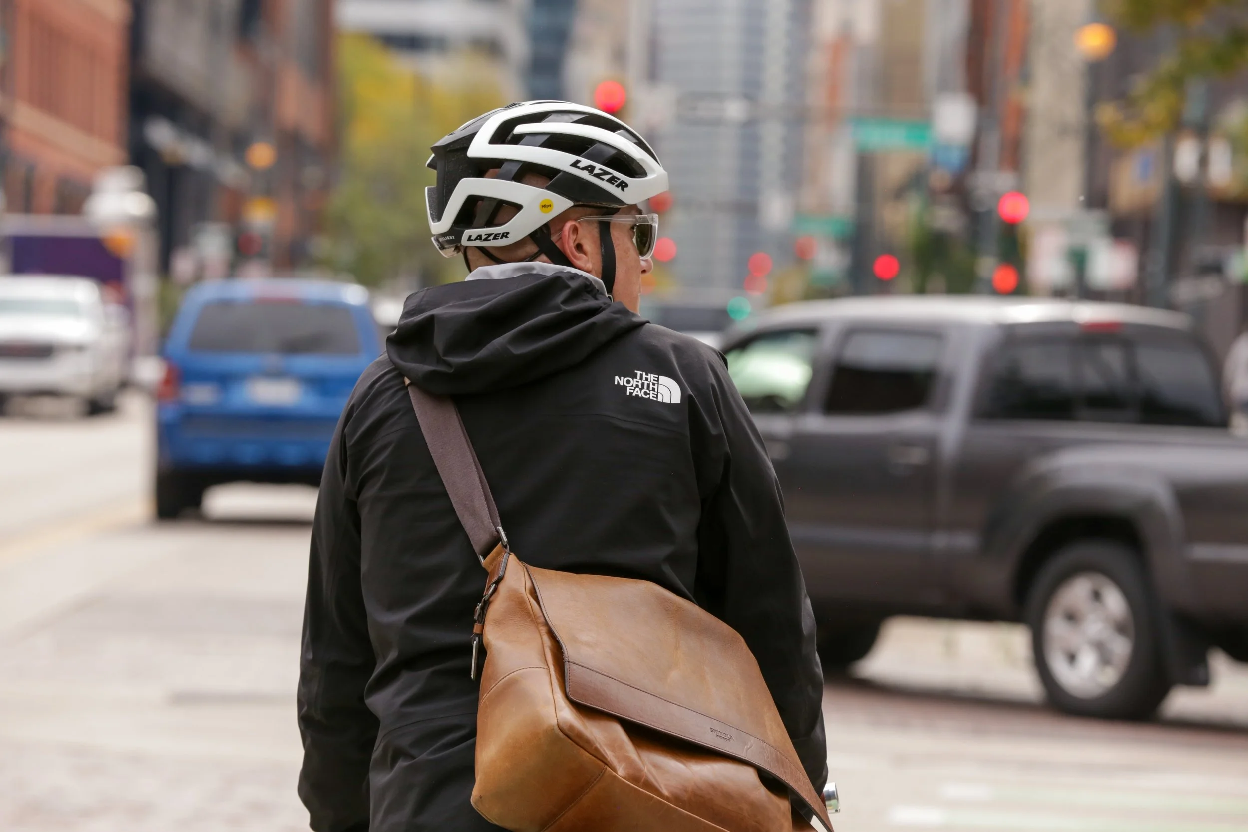 Person wearing helmet and North Face jacket walking on a Denver city street for brain injury resources